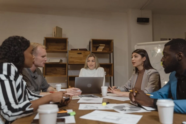 A group of people in a meeting room discussing and collaborating