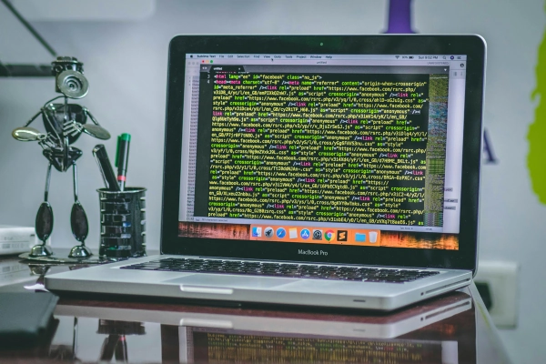 Laptop displaying code on screen in a creative workspace