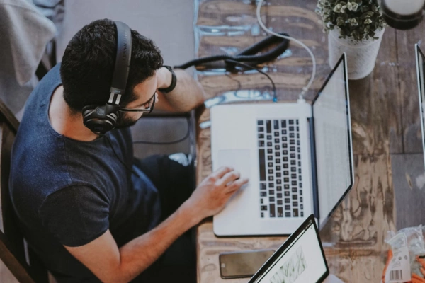 Overhead view of a person wearing headphones, working on a laptop