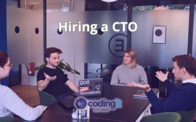 Four people in an office, engaged in a discussion around a table, with the text "Hiring a CTO" and CodingIT's logo