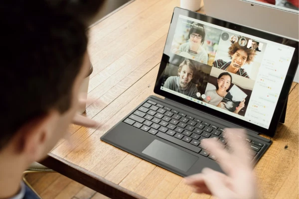 A virtual meeting on a laptop screen showing the software team members discussing remotely