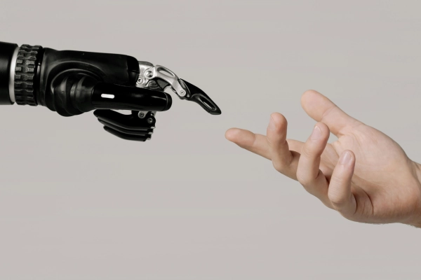 A robotic hand reaching out to shake hands with a human