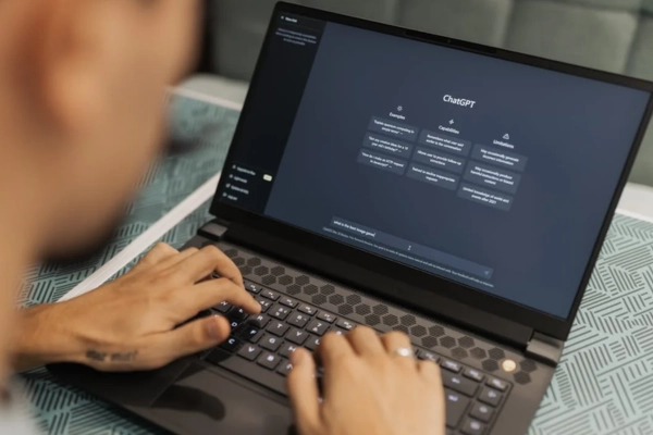 A person typing on a laptop running ChatGPT, illustrating AI adoption and usage