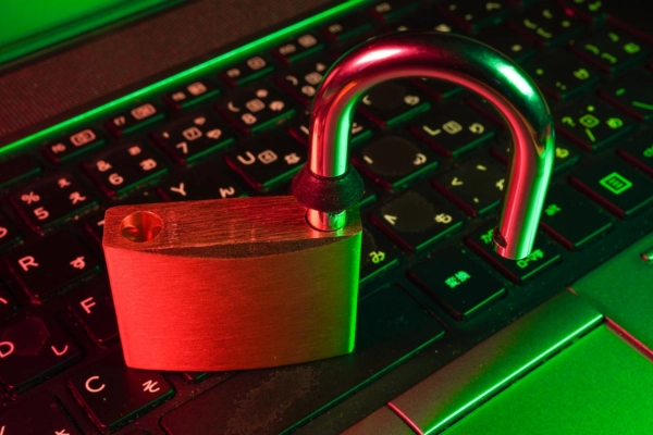 An unlocked padlock placed on a keyboard, symbolizing security vulnerabilities and risks