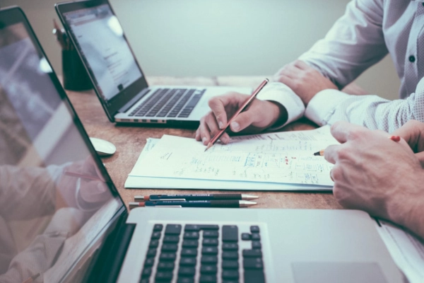 Hands reviewing notes and diagrams during a tech stack audit
